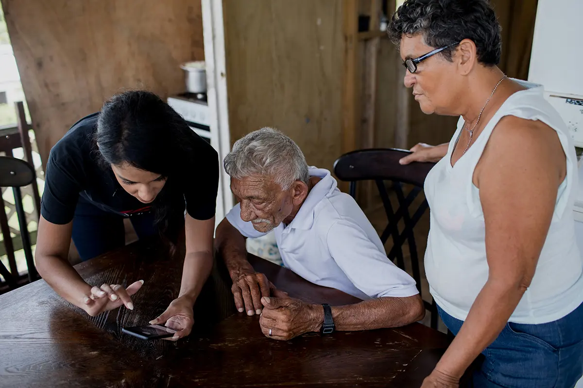 A caregiver and senior looking at a laptop together